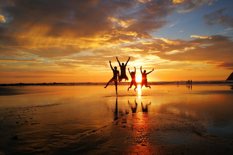 Silhouette photo of a group jump shot behind the sunset