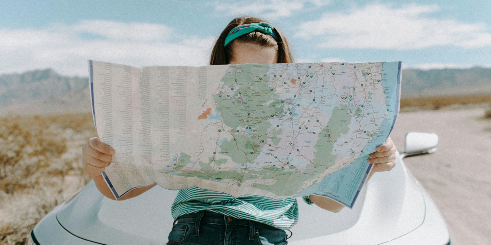 a woman holding and looking at a map