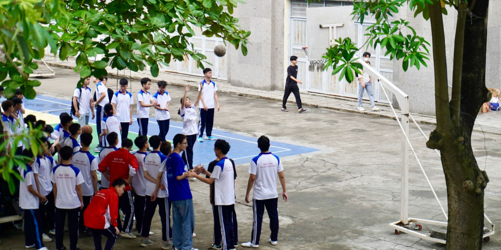 Vietnamese high school students playing basketball on campus
